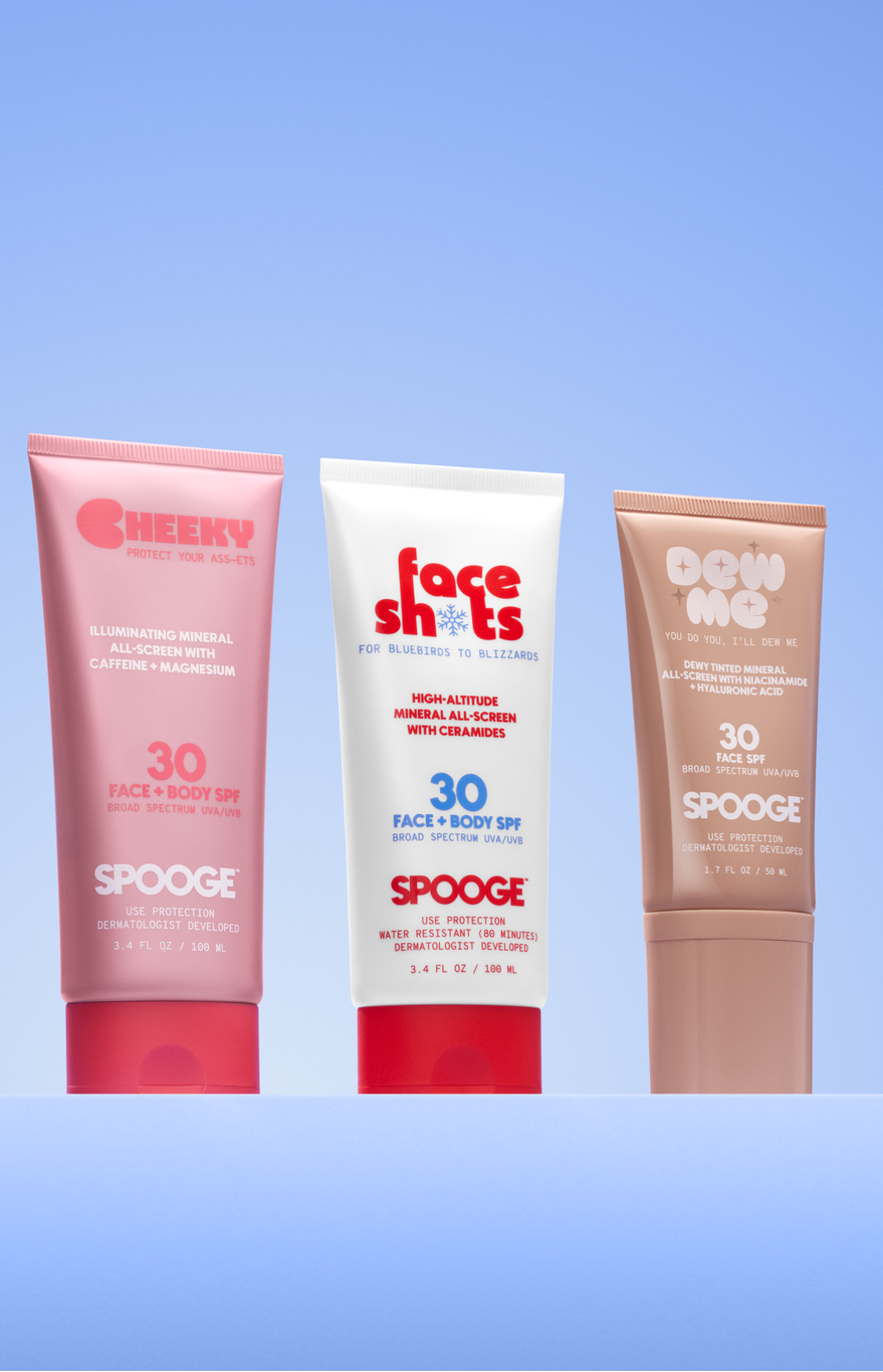 Five SPOOGE sunscreen tubes in assorted colors are lined up against a light blue gradient background. The tubes include shades of white, pink, red, brown, and blue, each with different brand graphics and SPF levels ranging from 30 to 50.